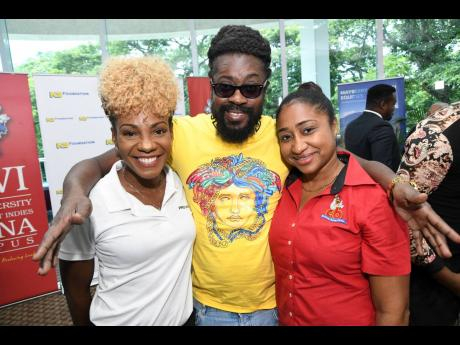 Entertainer Beenie Man is happy to be in the midst of beauties Belinda Williams (left), head of marketing and communications of PROVEN, and Venneshia Sinanan, corporate finance manager, CB Group.